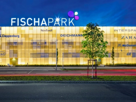 Ausschnitt der seitlichen Ansicht des Projekts der goldglänzenden Fassade bei Dämmerung, inklusive Beleuchtung.