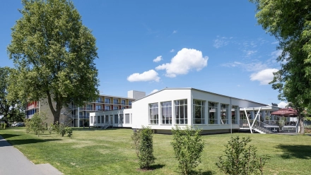 Schräge Ansicht des Vorplatzes, inklusive gesamten Objekts im Hintergrund.